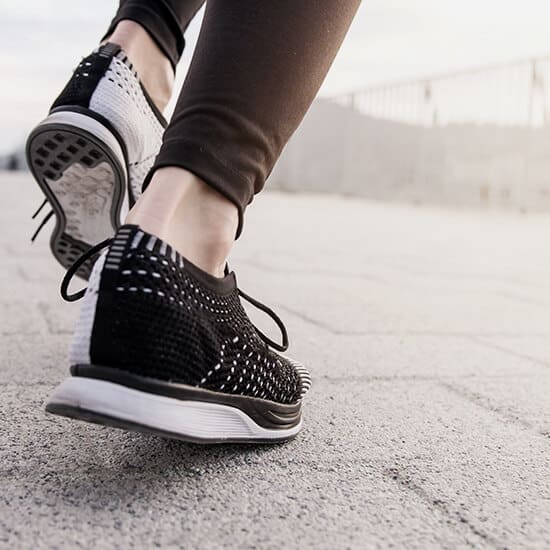 A woman's feet in black and white running shoes.