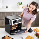 A woman is preparing food in an air fryer.