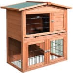 A wooden rabbit hutch with a green roof.