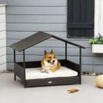 A dog laying in a wicker dog bed.