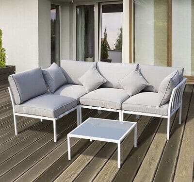 A white patio furniture set on a wooden deck.
