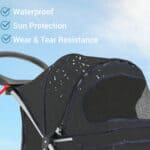 A black stroller with a rain cover on it.