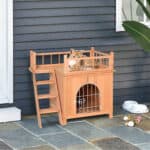 A cat in a wooden kennel.