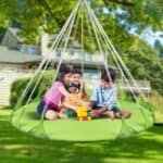 Kids playing on a swing in the yard.