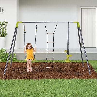 A little girl sitting on a swing set in a yard.