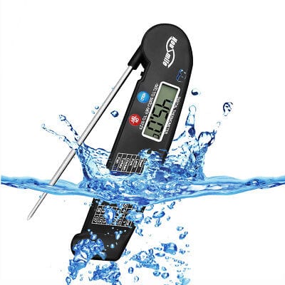A digital thermometer with water splashing on it.