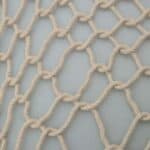 A close up of a rope net on a white surface.