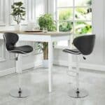 Two black bar stools in front of a table.