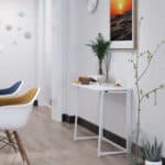 Modern living room corner with stylish chairs, a small table with snacks, and decorative plants.