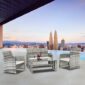 Luxury rooftop patio setup with modern furniture overlooking a city skyline at dusk.