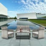 Modern outdoor patio arrangement with stylish chairs and a table set against an architectural backdrop under a blue sky with clouds.