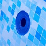 Blue umbrella fabric with a close-up view of its waterproof grommet.