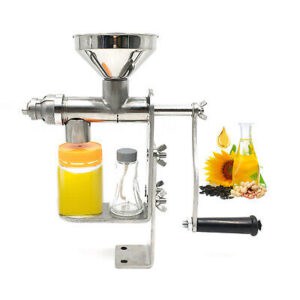 Manual oil press with various seeds and containers of extracted oil.