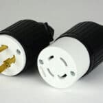 Two electrical plug adapters on a light background.