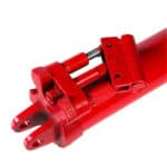 Red hydraulic bottle jack isolated on white background.