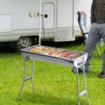 A man standing in front of an rv grill.