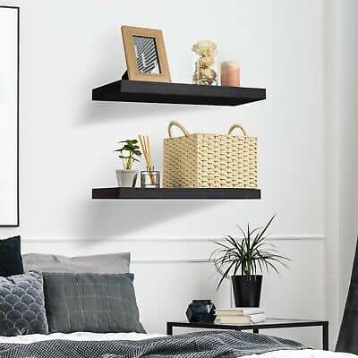 A black and white bedroom with two floating shelves.