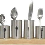 A set of stainless steel spoons and forks on a wooden base.