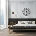 A black and white bedroom with a clock on the wall.