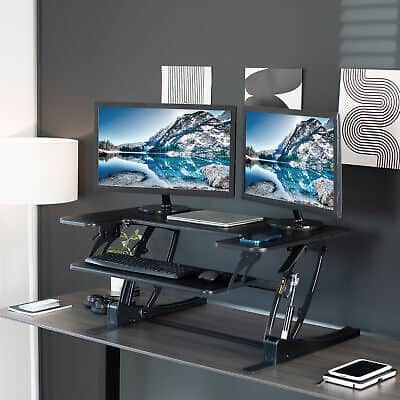 A desk with two monitors on top of it.