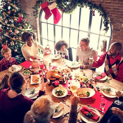 A group of people sitting around a table at a christmas dinner.