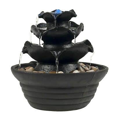 A black water fountain with blue stones in it.