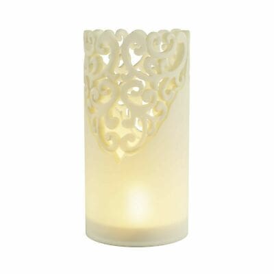A white candle with an ornate design on it.