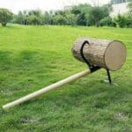 A wooden log sitting on the grass in a field.