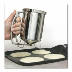 A person is making pancakes with a metal utensil.