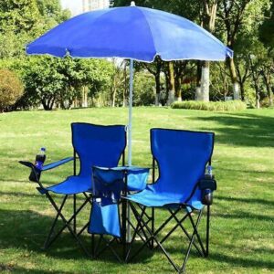 Two blue folding chairs with an umbrella in the grass.