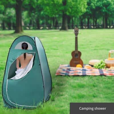 A woman is sitting in a tent with a guitar.
