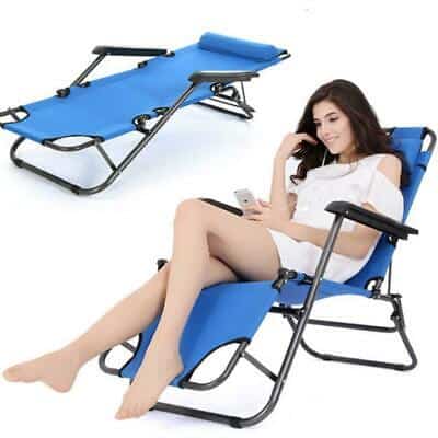 A woman is sitting on a blue folding lounge chair.