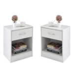 A pair of white nightstands with books and flowers.