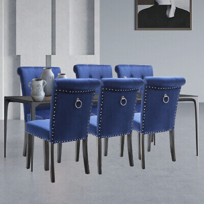 A set of blue velvet dining chairs with studs.