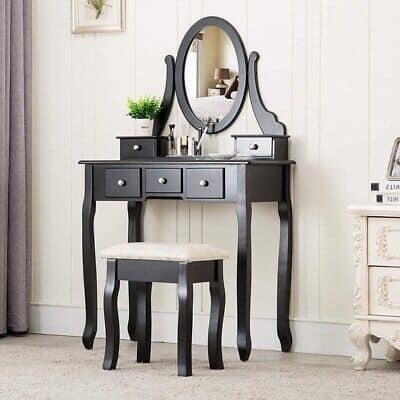 A black vanity table with a mirror and stool.