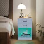 A white nightstand with a green light on top.