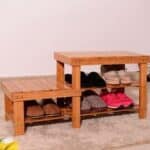 A wooden shoe rack with a pair of shoes on it.