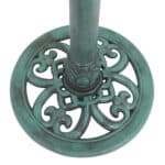 A green metal base with an ornate design.