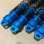 Four blue shock springs on a table.