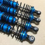 A set of blue shock absorbers on a table.