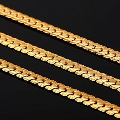 Three gold chain necklaces on a black surface.
