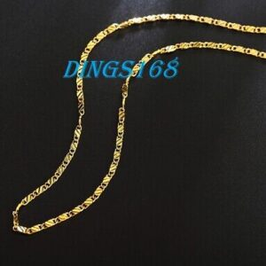 A gold plated chain necklace on a black background.