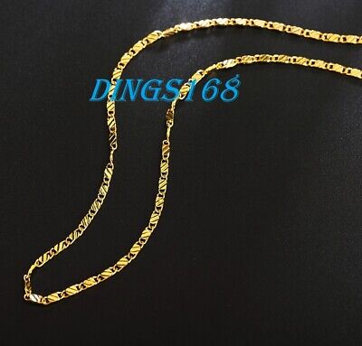A gold plated chain necklace on a black background.