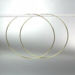 A pair of gold hoop earrings on a white background.