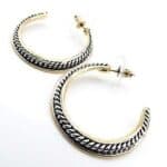 A pair of gold and silver hoop earrings.