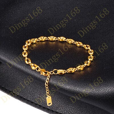 A gold chain bracelet on a black bag.