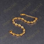 A gold plated chain bracelet on a black background.