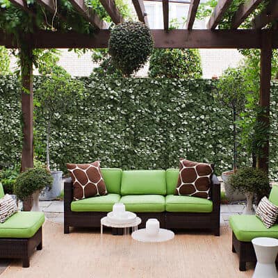 A patio with green furniture and green plants.