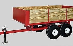A red trailer with a wooden box on it.