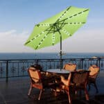 A table and chairs on a deck overlooking the ocean.